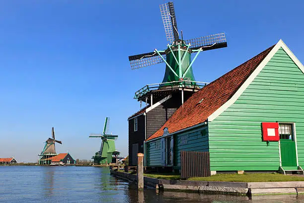 Photo of collection of historic windmills in a row at Zaanse Schans