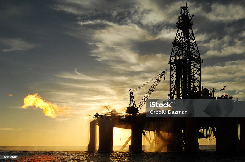 Silhouetted oil rig z duży gaz zaostrzenie choroby. - Zbiór zdjęć royalty-free (Platforma naftowa)