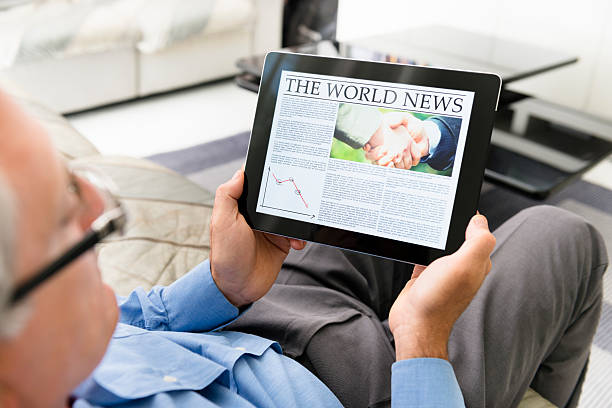 istock man reading  a World news newspaper on digital tablet 174951758