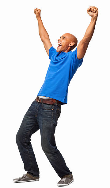 Excited Young Man - Isolated Full length of an excited young African American man in casuals cheering with arms up. Vertical shot. Isolated on white. exhilaration stock pictures, royalty-free photos & images