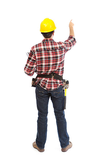 Back of a Pointing Construction Contractor Workman on White Background Subject: Back of a professional construction worker contractor carpenter with hard hat and work tools pointing with finger, isolated on a white background. sign human hand pointing manual worker stock pictures, royalty-free photos & images