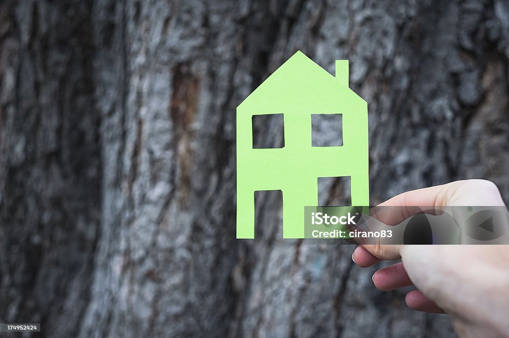 Mãos segurar casa verde contra casca de árvore - Foto de stock de Ação Climática royalty-free
