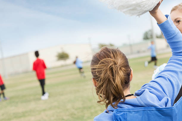 istock Soccer mom waving pompoms, cheering for kids during game 174952641