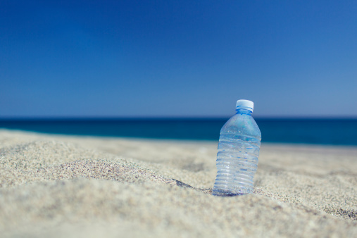 Empty plastic bottle on the sand beach.