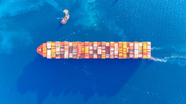 istock Top view Logistics and transportation  a tugboat is pulling a cargo ship. docked of Container Cargo ship and Cargo plane with working crane bridge in shipyard at sunrise, logistic import export and transport 1749532716