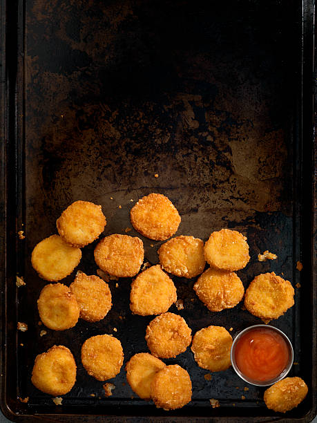 Chicken Nuggets All White Meat Chicken Nuggets with Sweet and Sour Sauce on a baking tray - Photographed on Hasselblad H3D2-39mb Camera nuggets heat stock pictures, royalty-free photos & images