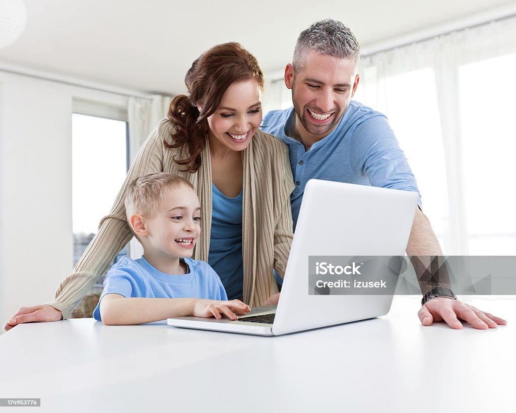 Happy Family using laptop Close up of a happy family using laptop at home. 25-29 Years Stock Photo