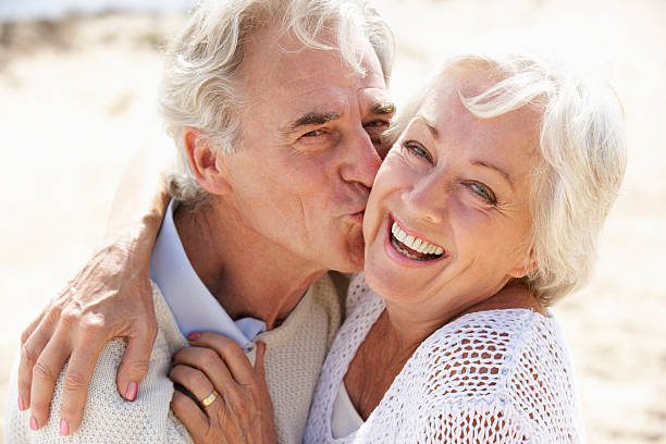 istock Senior Couple Walking Along Beach Together 174954862