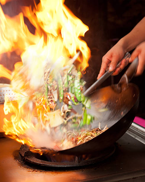 wok friendo con llamas - wok fotografías e imágenes de stock