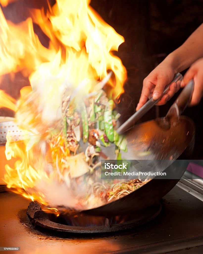 Сковорода вок frying с пламя - Стоковые фото Сковорода вок роялти-фри