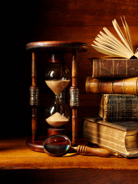 istock Rustic Hourglass with a Stack of Books and Magnifying Glass 174955505