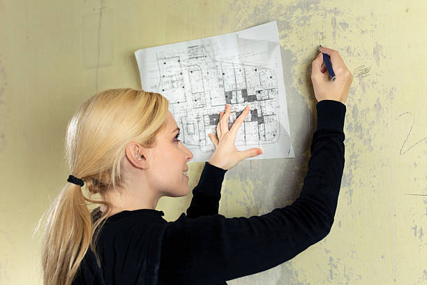 istock Young woman marking the wall - home renovation 174956135