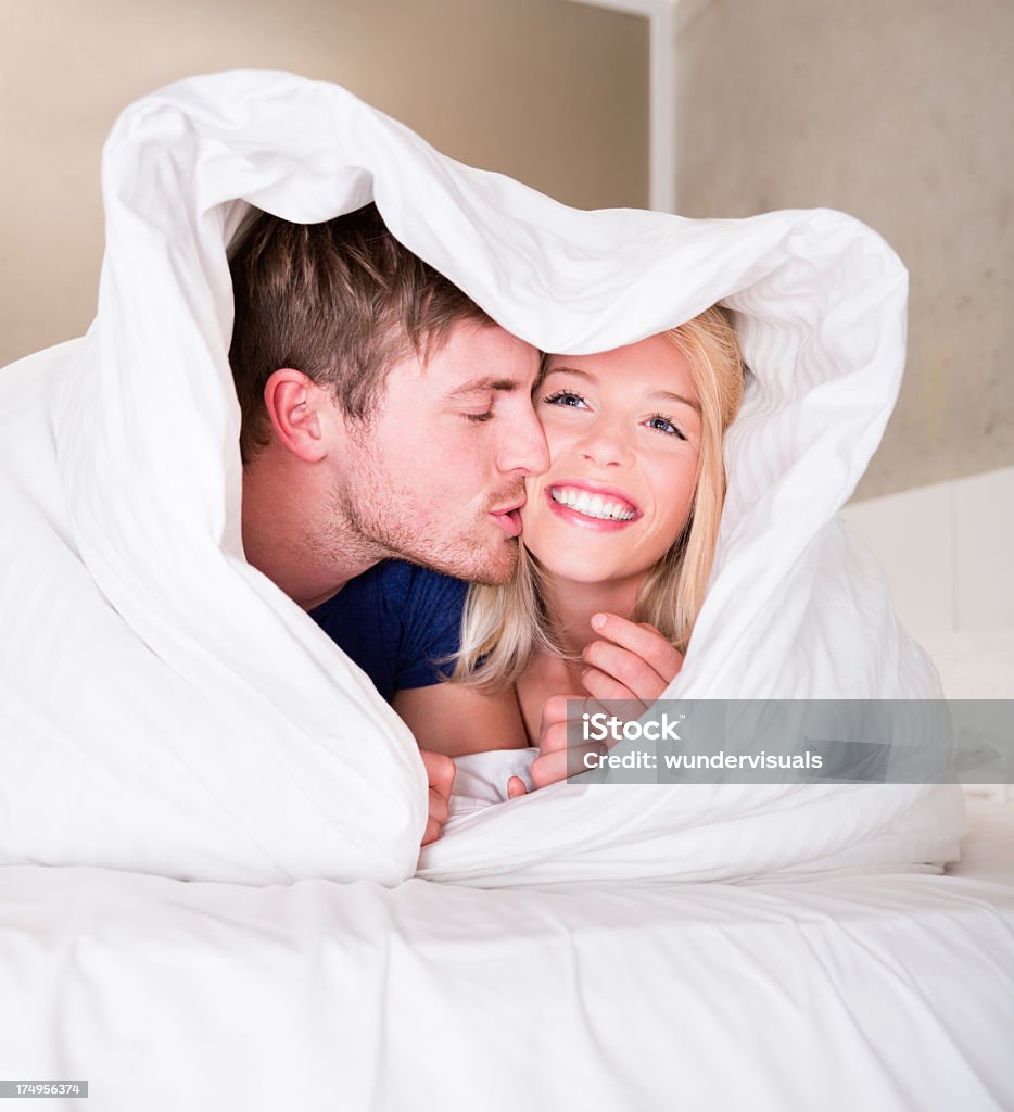 Happy Young couple having fun under blanket Young couple having fun under heartshape blanket Blanket Stock Photo