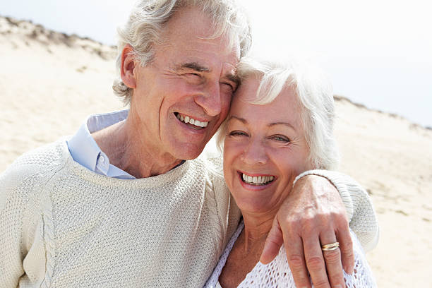 istock Senior Couple Walking Along Beach Together 174956570