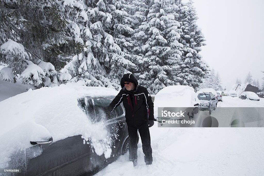 Uomo anziano rimozione di neve dalla sua auto - Foto stock royalty-free di Ambientazione esterna