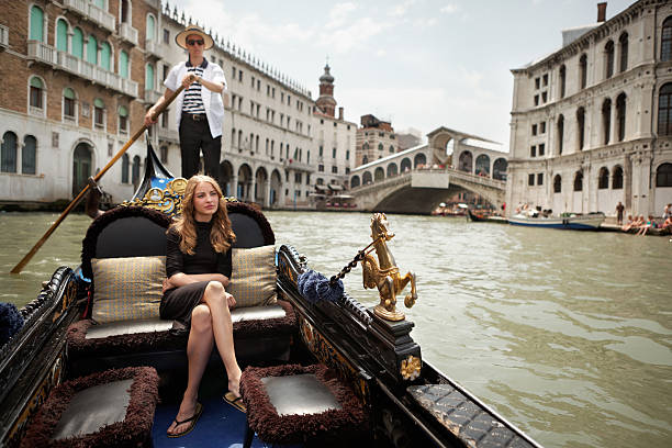 Gondola on the Grand Canal of Venice "Young woman in gondola, Venice. Rialto bridge in the background." gondolier stock pictures, royalty-free photos & images