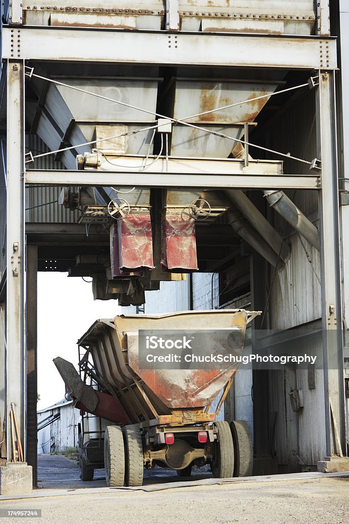 Grain Silo Truck Loading Station Granary delivery system involving large bins and chutes that dispense the grain into waiting trucks. Soybean Stock Photo