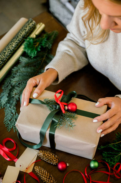 istock woman wrapping christmas gift at home 1749580867