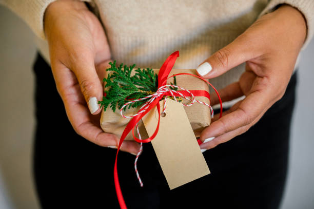 istock An unrecognizable woman holding Christmas gift in hand 1749582027