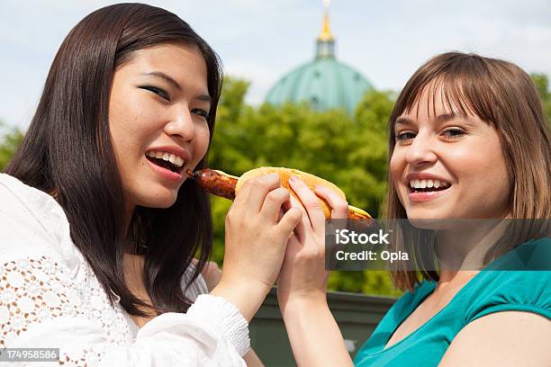Two Young Women Sharing A Sausage Roll Stock Photo - Download Image Now - 20-24 Years, 25-29 Years, Adult