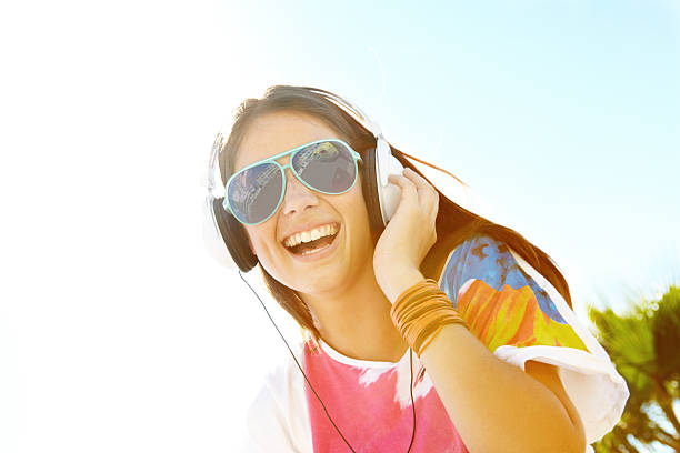 beautiful girl listening to music on headphones in the sky