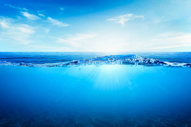 istock BLUE UNDER WATER waves and bubbles. Beautiful white clouds on blue sky over calm sea with sunlight reflection, Tranquil sea harmony of calm water surface. 1749588499