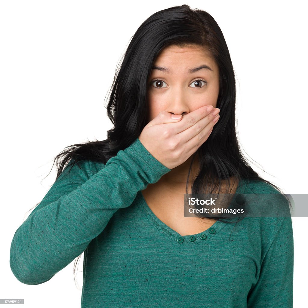 Shocked Teenage Girl Covering Mouth With Hand Portrait of a teenage girl isolated on a white background.  Displeased Stock Photo