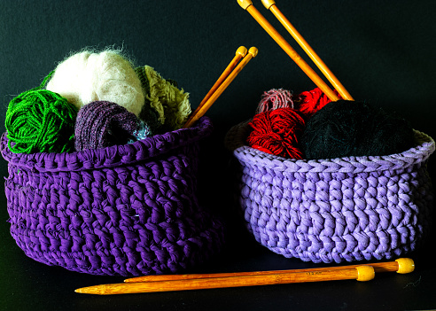 crocheted basket with different yarn threads, women's hobby knitting, color thread for knitting, knitting concept