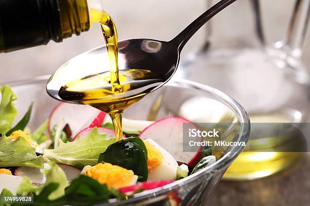 Adding Dressing To A Salad In A Glass Bowl Stock Photo - Download Image Now - Olive Oil, Salad, Cooking Oil