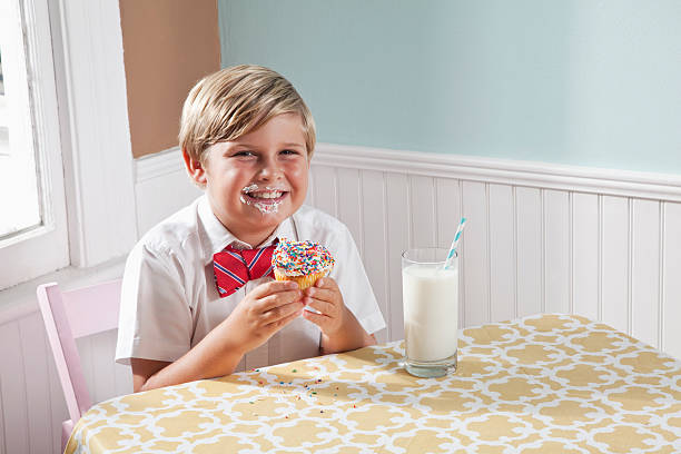 menino com um cupcake e uma taça de leite - sc0563 - fotografias e filmes do acervo