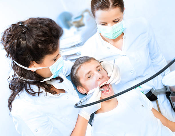 стоматологическое хирургическое вмешательство - mouth open human teeth doctor dental drill стоковые фото и изображения