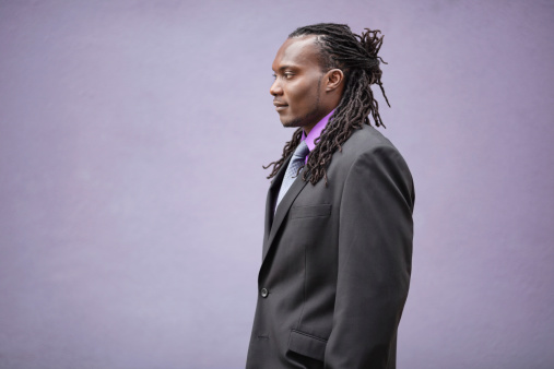 Profile shot of young African American businessman with dreadlocks