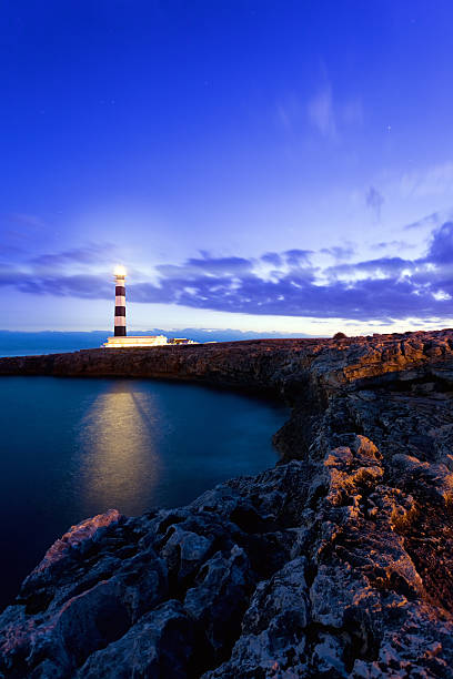 Lighthouse Mediterranean lighthouse in Menorca. Far de Artrutx. Minorca. Spain. lighthouse lighting equipment reflection rock stock pictures, royalty-free photos & images