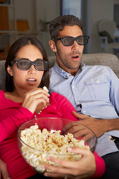istock Couple On Sofa Watching TV Wearing 3D Glasses 174960611