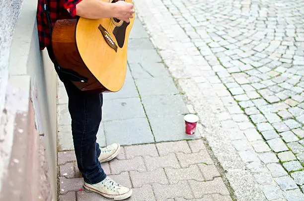 Photo of Young street musician plays the guitar
