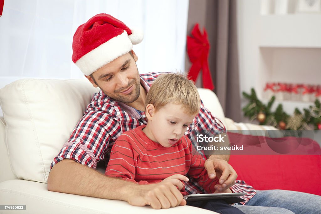 Father with son. "Father with son using digital tablet with christmas decoration in background. Please, see CHRISTMAS images with this FAMILY, for lightbox click the image below." 30-39 Years Stock Photo