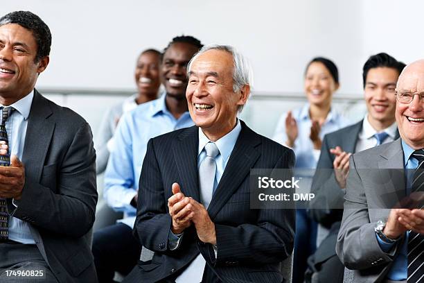 Foto de Grupo De Empresários Aplaudindo Uma Convenção e mais fotos de stock de Terceira idade - Terceira idade, Seminário - Reunião, Asiático e indiano