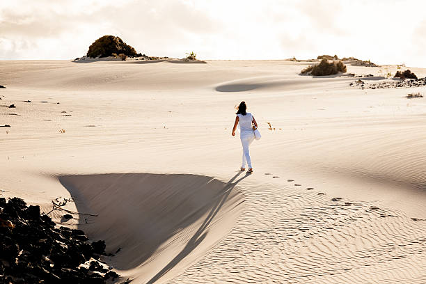 mulher caminhando no parque de corralejo. fuerteventura - volcanic landscape rock canary islands fuerteventura - fotografias e filmes do acervo