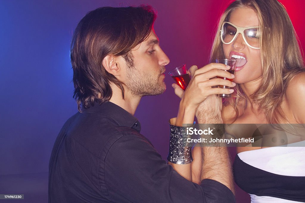 Couple Drinking Jello Shots Young man and woman drinking jello shots in nightclub. Horizontal shot Sensuality Stock Photo