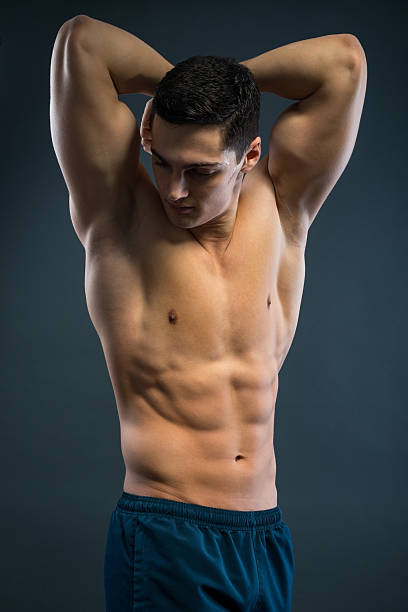 молодой musular человек над серый фон - sex symbol the human body male abdomen стоковые фото и изображения