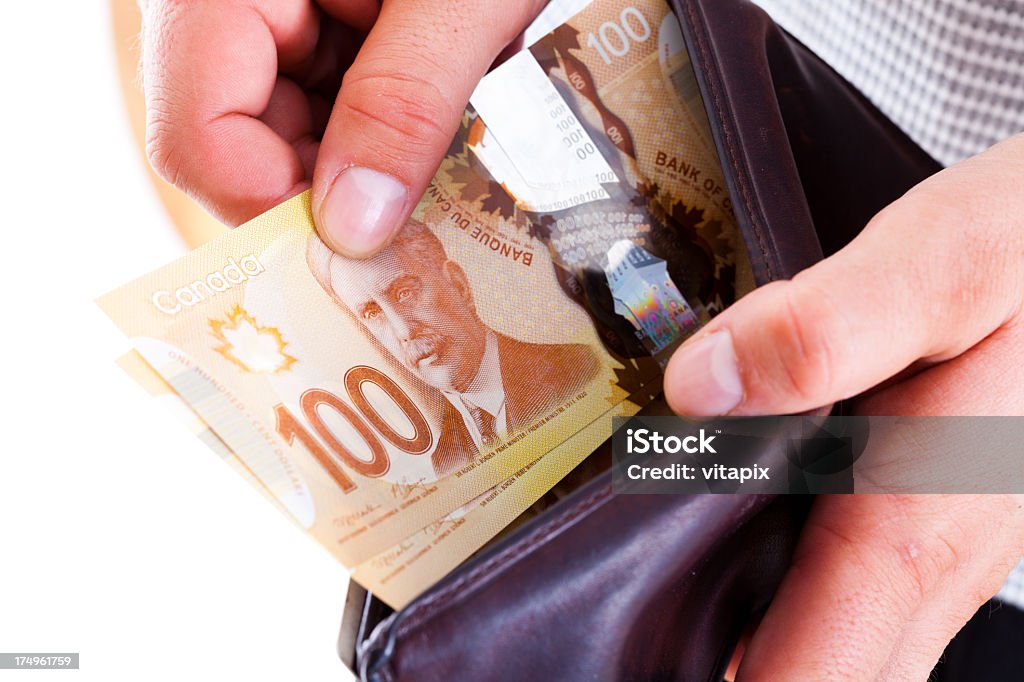 Spending money Man taking out canadian $ 100 bills out of his wallet. New bills issues in 2012. Canadian Dollars Stock Photo