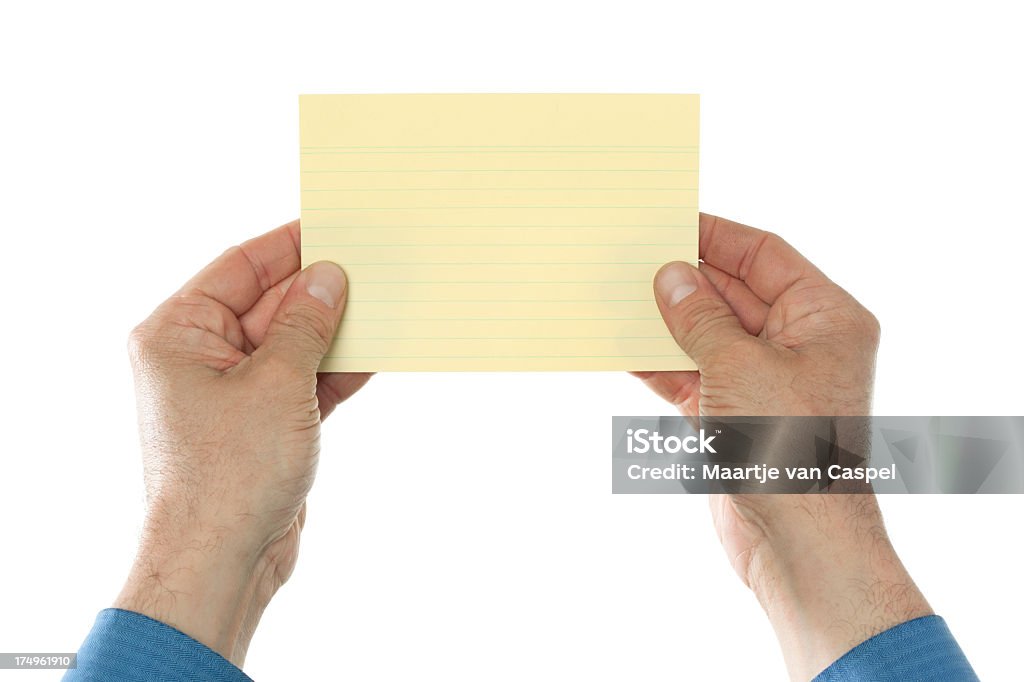 Business hands holding yellow index card Two hands in shirt and suit holding a yellow index card in front of the camera.  Empty paper as copy space, isolated on white background. Adult Stock Photo