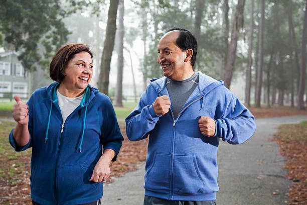 altes hispanische paar joggen im park - senior couple couple partnership discussion stock-fotos und bilder