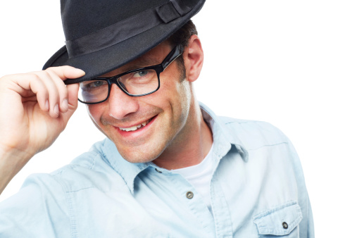 A smiling mature man tipping his hat to you while isolated on a white background