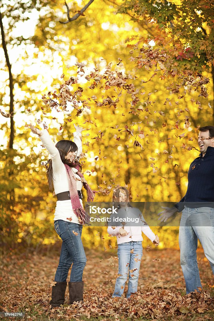 Famiglia di tre giocando in autunno Woods - Foto stock royalty-free di Bambino