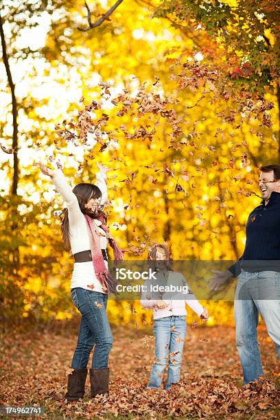 Famiglia Di Tre Giocando In Autunno Woods - Fotografie stock e altre immagini di Bambino - Bambino, Genitori, Giocare