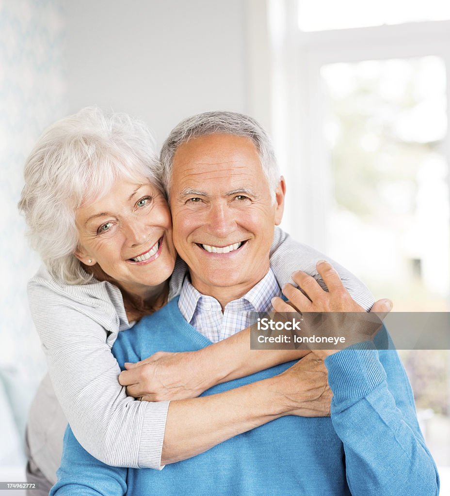 Alegre Senior par abrazar en su casa - Foto de stock de 60-69 años libre de derechos
