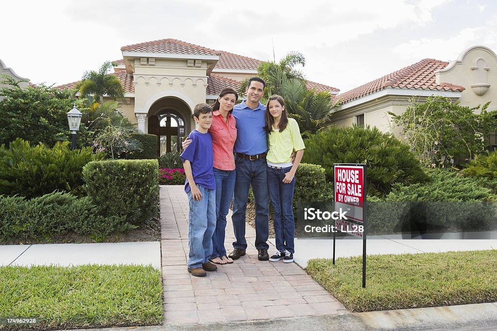 Famiglia in piedi di per segno vendita casa - Foto stock royalty-free di 14-15 anni