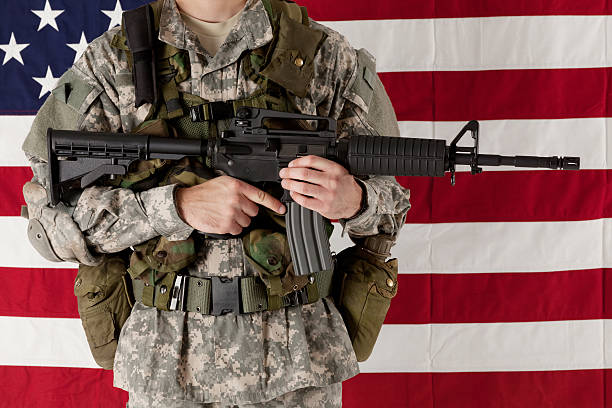 istock Army man standing in front of american flag with rifle 174962929