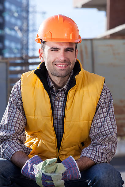 istock Happy worker is sitting near Construction Site in hardhat. 174964031